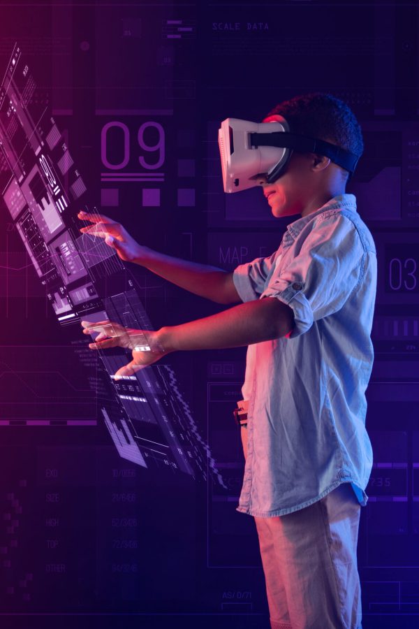 Illuminated projection. Calm clever progressive boy wearing virtual reality glasses and feeling interested while creating a detailed hologram